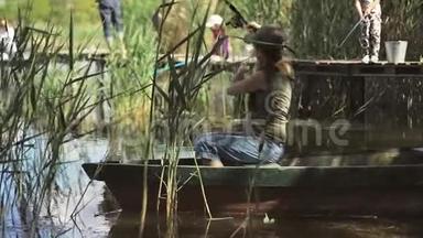 年轻<strong>女</strong>子<strong>渔</strong>夫正在森林湖上钓鱼，拿着鱼竿扭动着线圈。